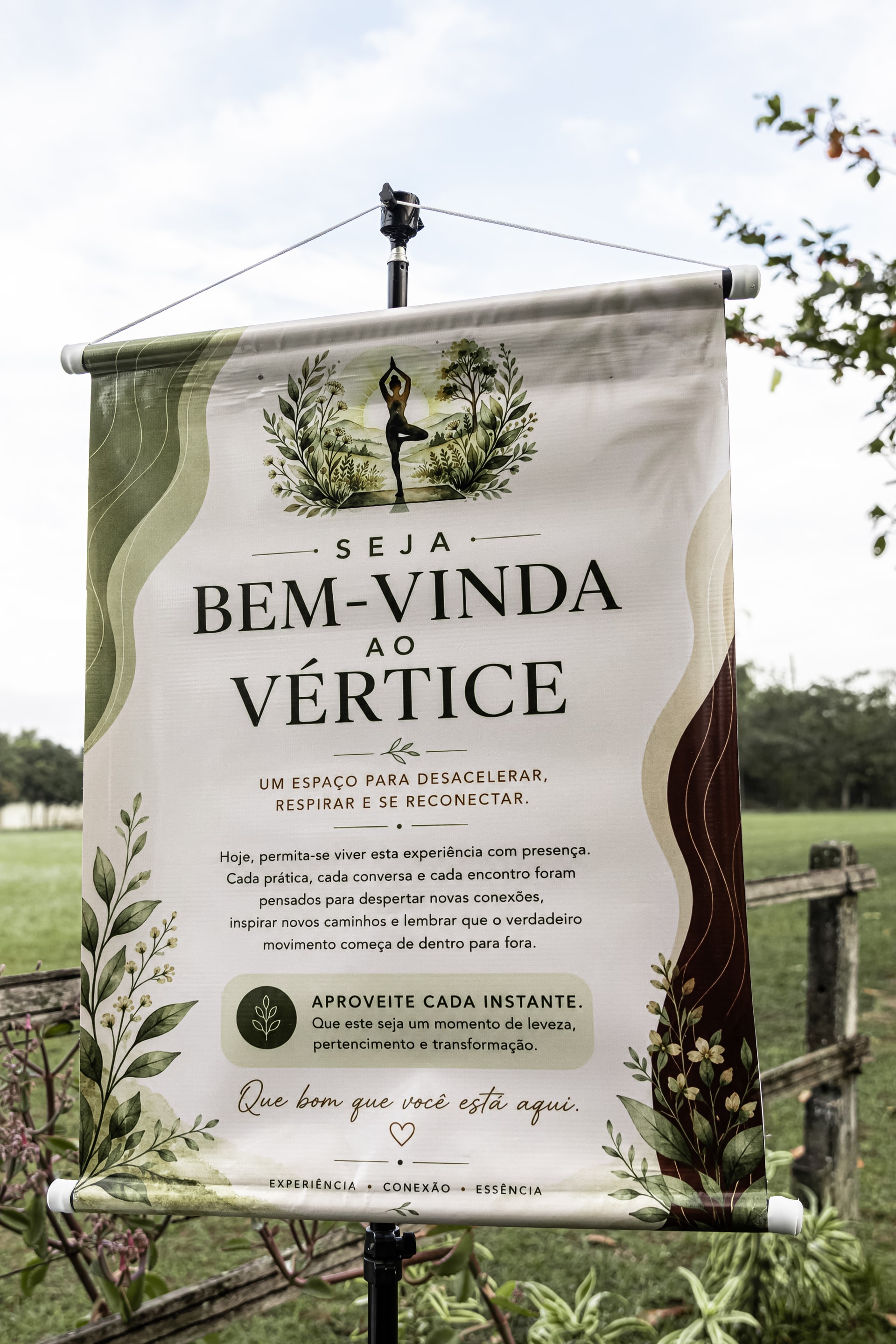 Banner de boas-vindas à Vértice diante do campo